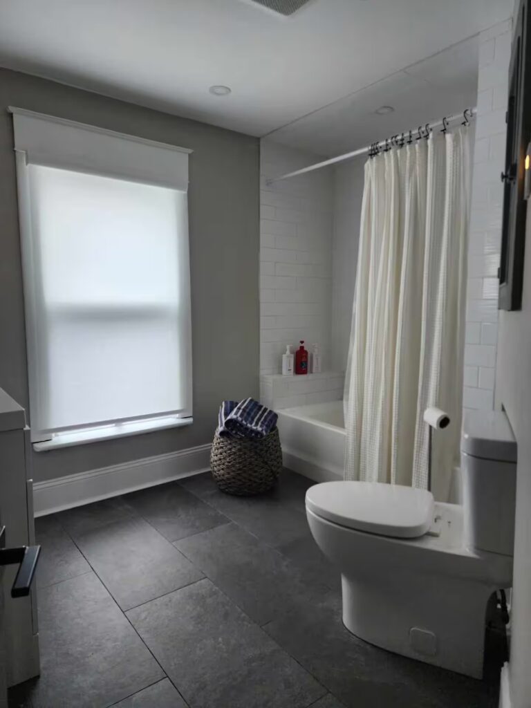 Full bathroom with a bathtub and window in a furnished Niagara Falls rental