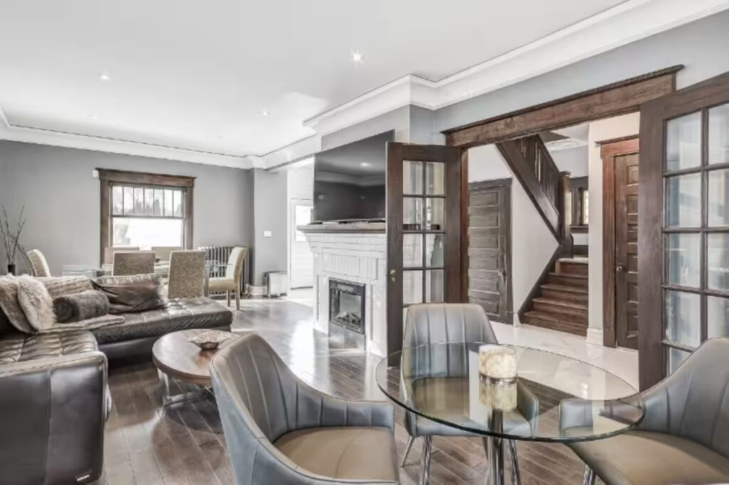 Open living and dining area with a glass table in a furnished Niagara Falls home