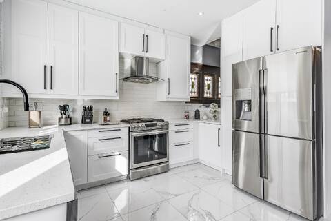 Modern white kitchen with stainless steel appliances in a Niagara Falls furnished rental